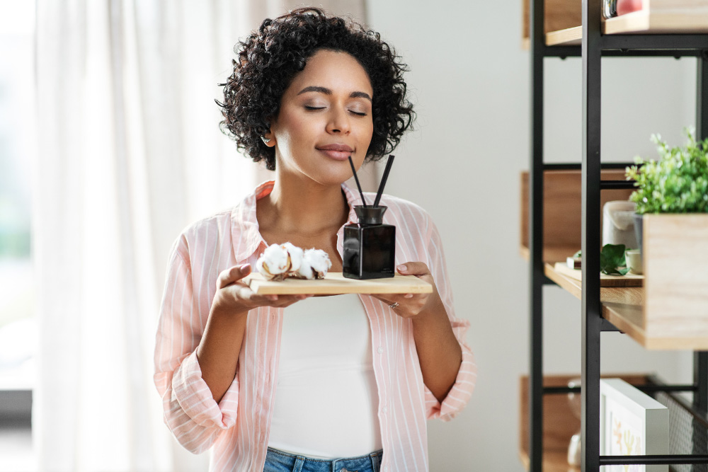 Una mujer disfruta de un ambiente tranquilo con el aroma natural de los aceites esenciales.