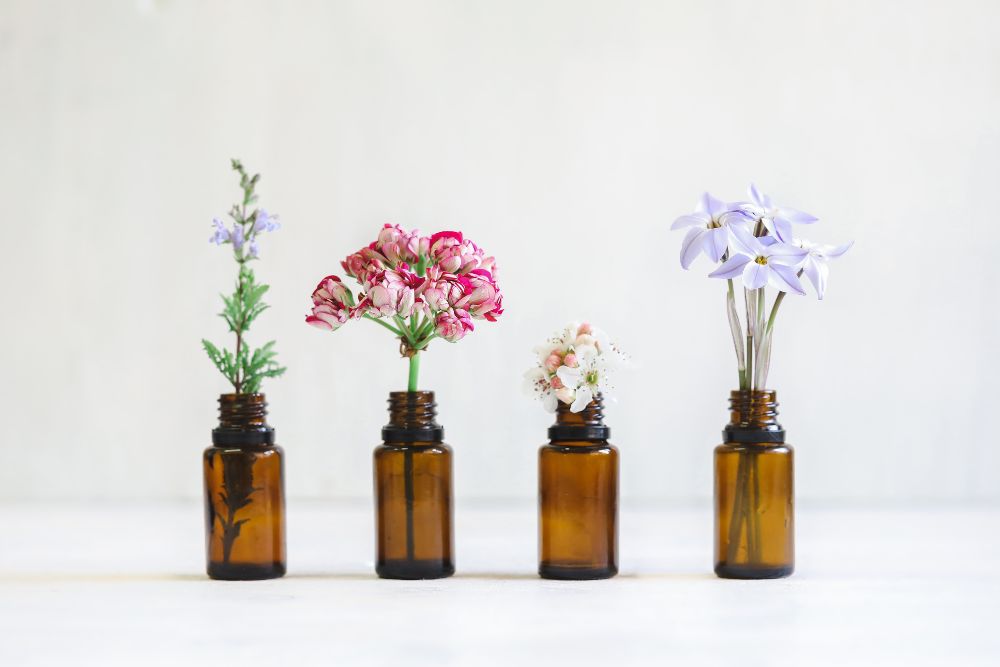 Diferentes tipos de aceites esenciales - aceite de lavanda, limón y menta con plantas frescas