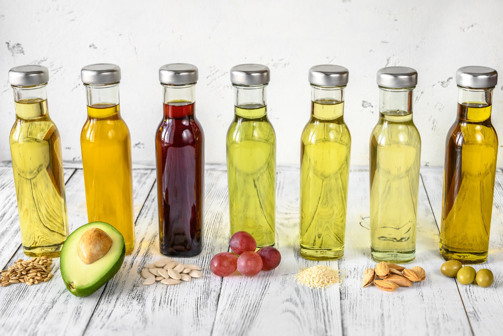 Distintos tipos de aceites portadores naturales en frascos: aguacate, pepitas de uva, oliva y otras materias primas