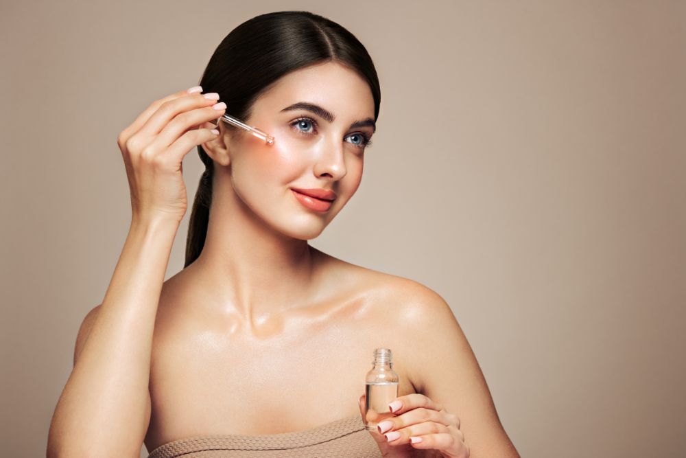 Mujer aplicando un sérum facial natural con aceites esenciales en el rostro