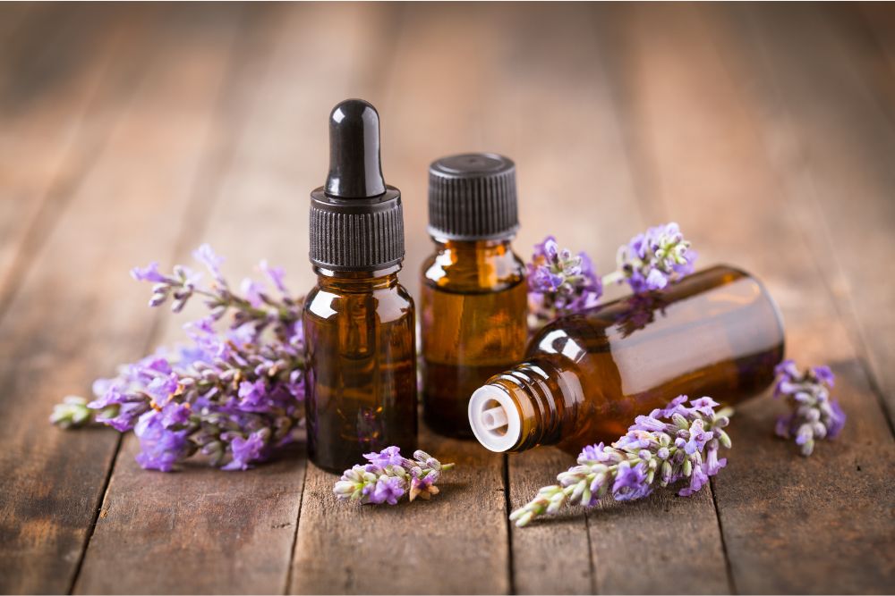 Frascos de aceite esencial de lavanda y flores de lavanda sobre una mesa de madera: cosmética natural.