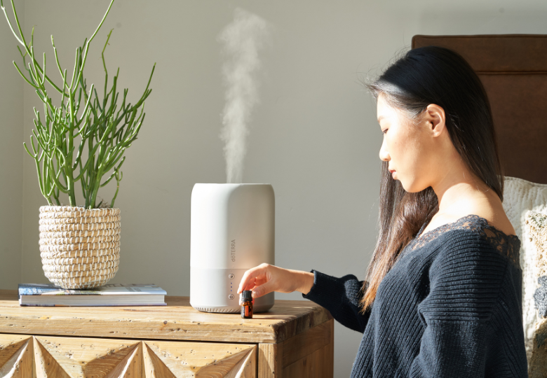 Una mujer echa aceite esencial en un difusor de aromas como parte de la preparación para una noche tranquila.